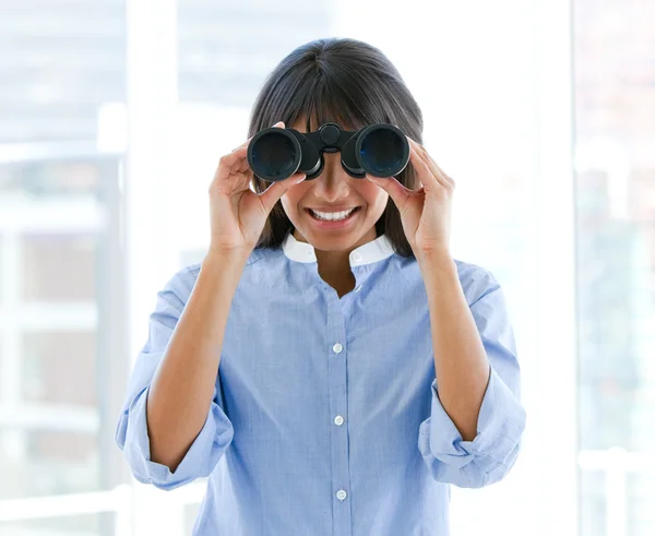 Positive female executive looking through binoculars — Stock Photo, Image