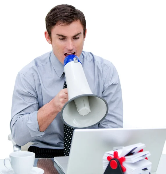 Arrabbiato uomo d'affari urlando attraverso un megafono seduto al suo des — Foto Stock