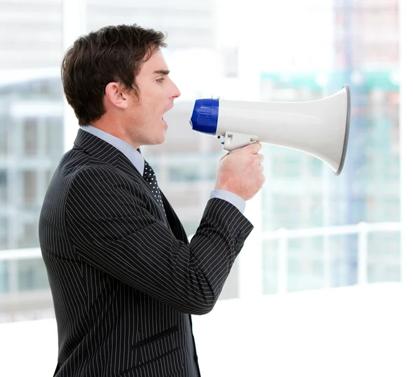 Frustrated businessman yelling through a megaphone — Stock Photo, Image