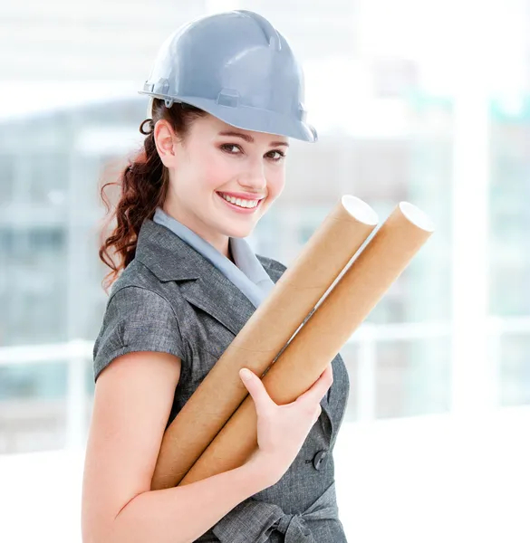 Portrait of a smiling female architect holding blueprints — Stock Photo, Image