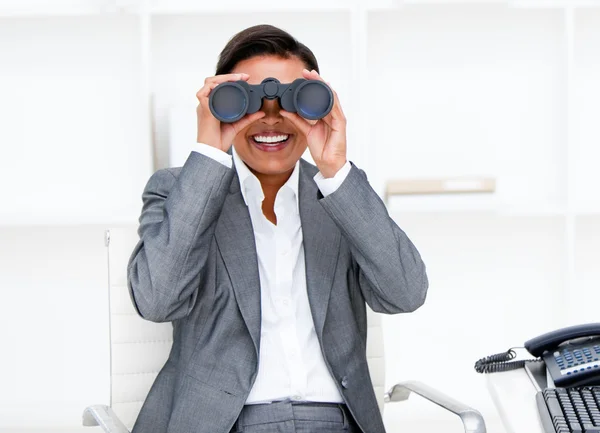 Jolly businesswoman looking through binoculars — Stock Photo, Image