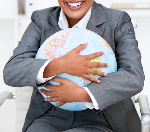 Close-up of a smiling businesswoman holding a terrestrial globe — Stock Photo, Image