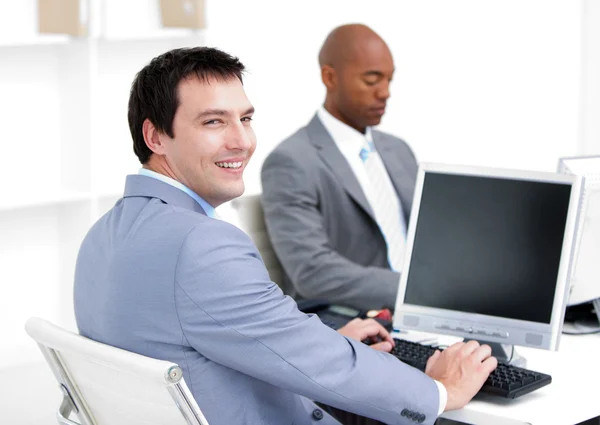 Счастливые молодые бизнесмены, работающие за компьютером — стоковое фото