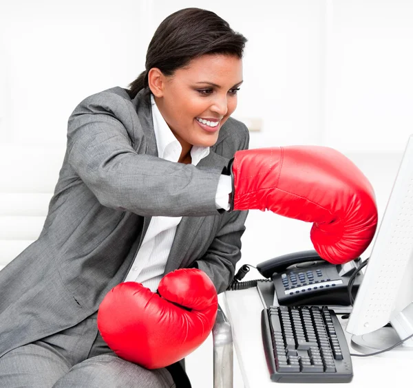 Bir bilgisayar yumruk boks eldivenli genç iş kadını — Stok fotoğraf