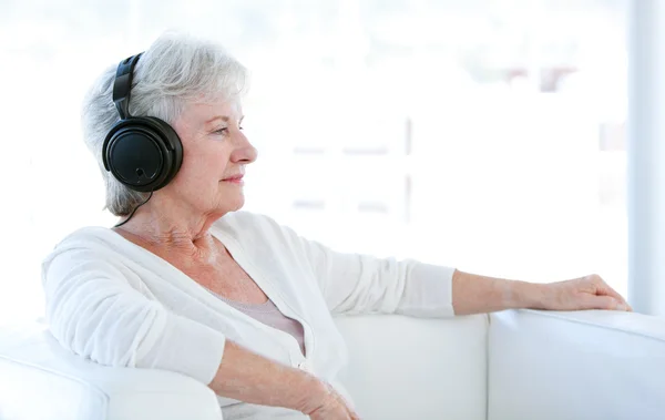 Пожилая женщина слушает музыку с наушниками — стоковое фото
