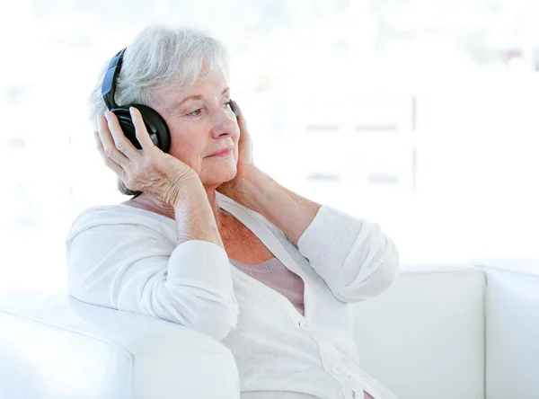 Encantadora mujer mayor escuchando música con auriculares —  Fotos de Stock