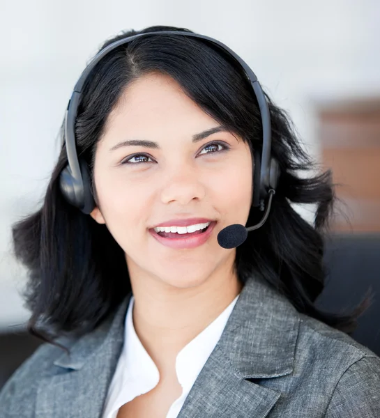 Donna d'affari sorridente che indossa un auricolare per parlare con il cliente — Foto Stock