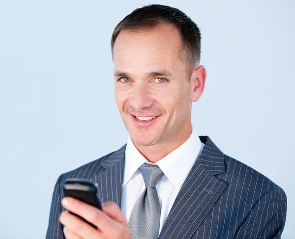 Уверенный бизнесмен отправляет смс со своим телефоном — стоковое фото