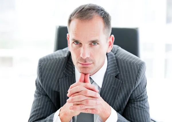 Serious businessman looking at the camera sitting — Stock Photo, Image