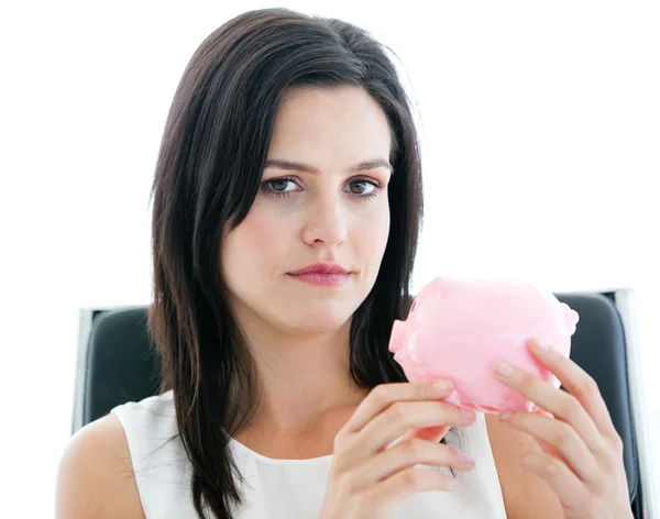 Beautiful businesswoman holding a piggybank and looking at the c — Stock Photo, Image