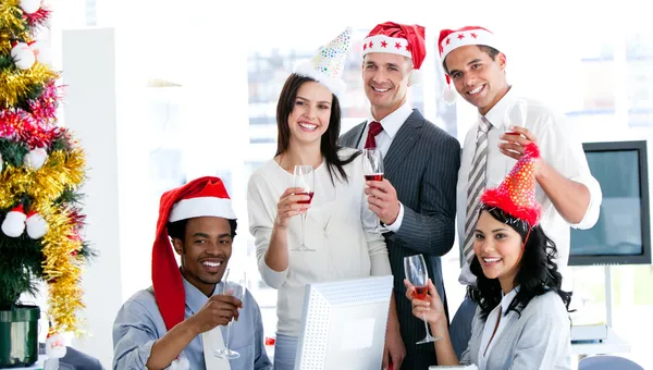 Sorrindo equipe de negócios bebendo champanhe para celebrar o Natal — Fotografia de Stock