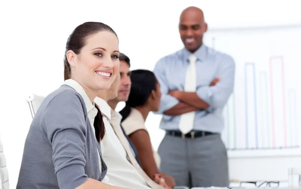 Lächelnde Geschäftsfrau, die bei einem Meeting in die Kamera schaut — Stockfoto