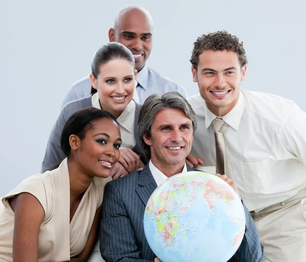Многонациональные предприниматели держат земной шар в офисе — стоковое фото