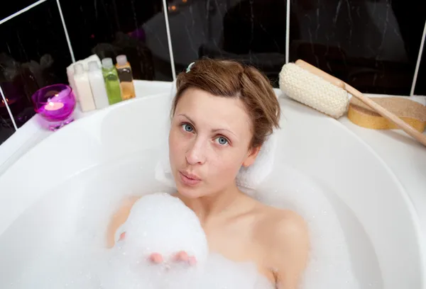 Aantrekkelijke vrouw spelen in een bad van bellen — Stockfoto