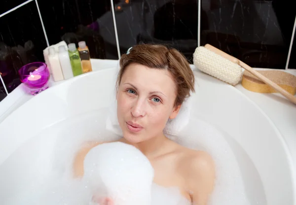 Jovem mulher brincando em um banho de espuma — Fotografia de Stock