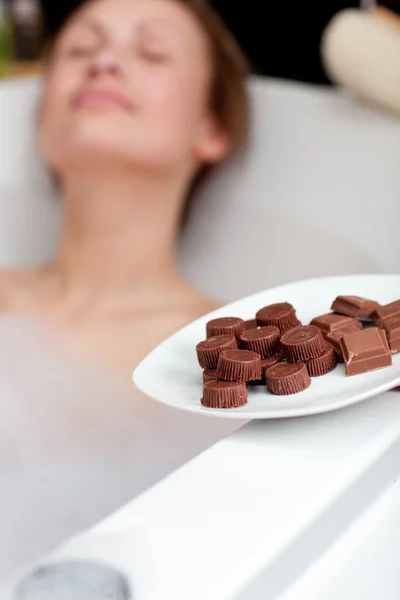 Étkezési csokoládét, miközben egy fürdő, vonzó nő — Stock Fotó