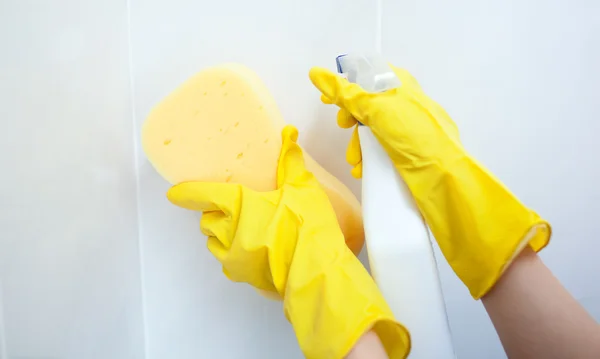Primo piano di una donna che pulisce con una spugna e uno spray detergente — Foto Stock