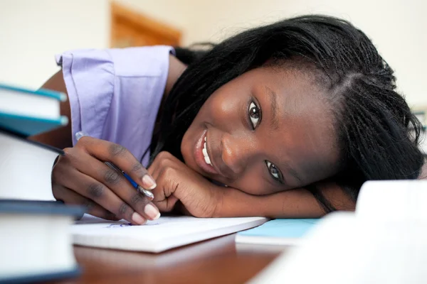 Vrolijke tiener meisje haar huiswerk — Stockfoto