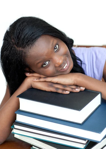 Gülümseyen öğrenci kitap yığınına yaslanıyor. — Stok fotoğraf