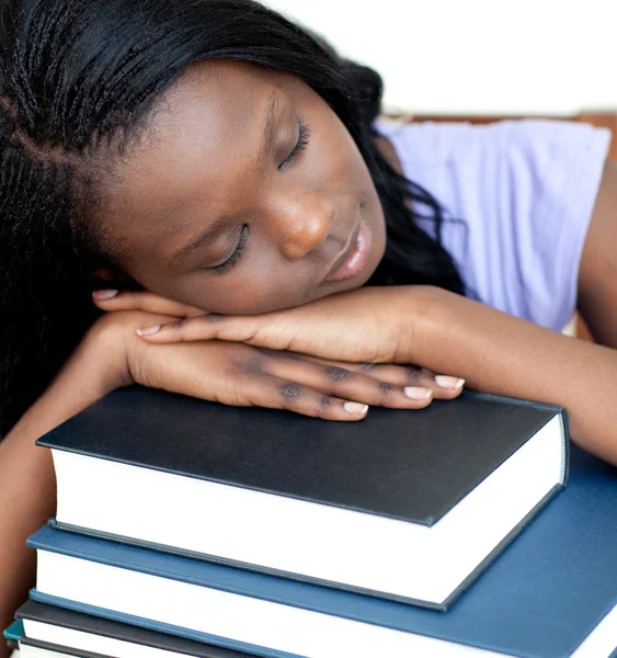 Estudante exausto apoiado em uma pilha de livros — Fotografia de Stock
