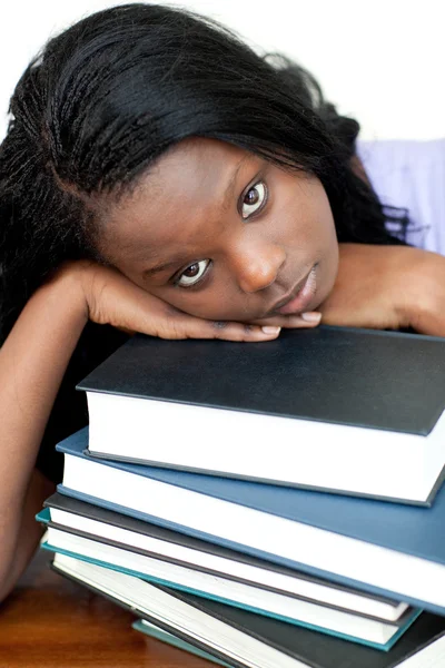 Tired student leaning on a stack of books — Stock Photo, Image