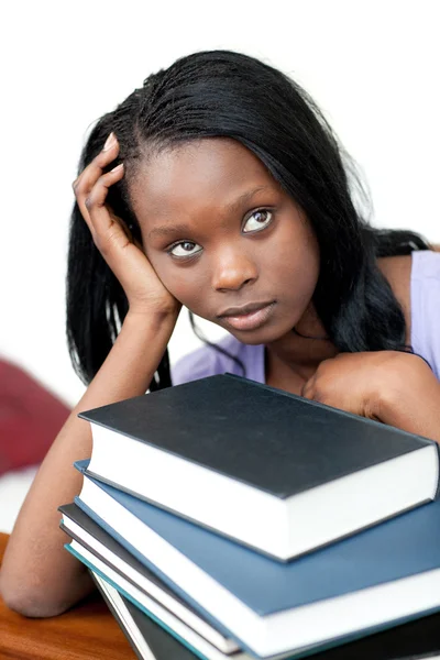 Estudante perturbado inclinado em uma pilha de livros — Fotografia de Stock