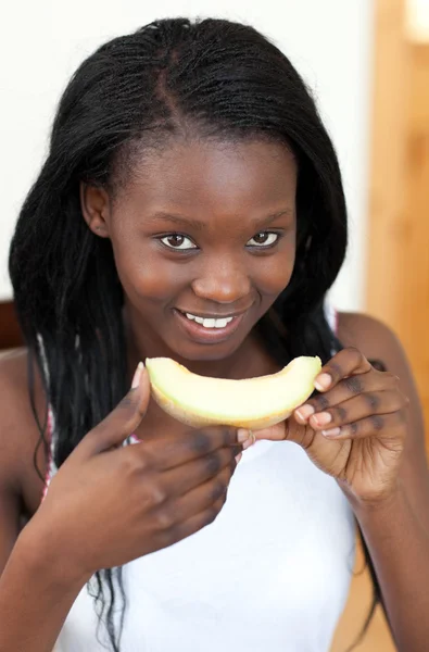 Mujer afroamericana sonriente comiendo melón —  Fotos de Stock