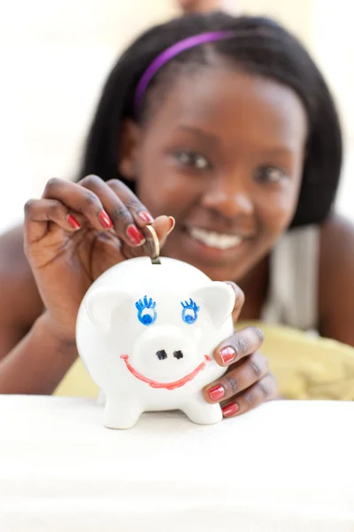 Gelukkig tiener meisje geld steken in een piggy-bank — Stockfoto