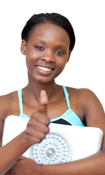Charming fitness woman with thumb up holding a weight scale — Stock Photo, Image