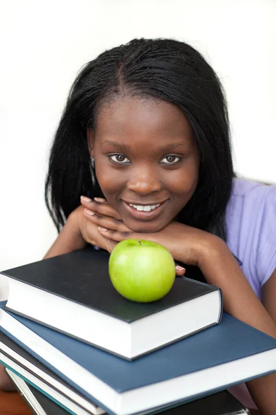 Joven estudiante sosteniendo libros sonriendo a la cámara — Foto de Stock