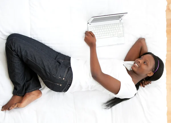 stock image Happy woman surfing the internet lying on a bed