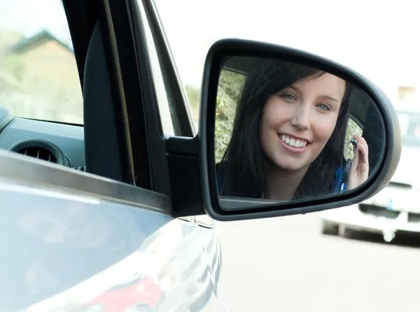 Brunett tonåring flicka sitter i hennes bil hålla knapparna — Stockfoto