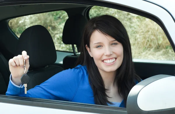 Jolly teen dziewczyna siedzi w jej samochodzie przytrzymanie klawiszy — Zdjęcie stockowe