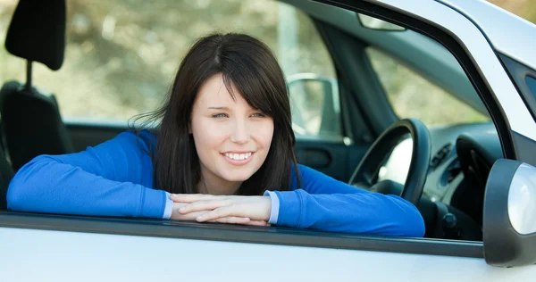 Γοητευτικό κορίτσι χαμογελά στη φωτογραφική μηχανή κάθεται στο αυτοκίνητό της — Φωτογραφία Αρχείου