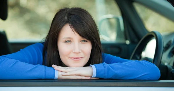 Симпатична дівчина-підліток посміхається на камеру, сидячи в її машині — стокове фото