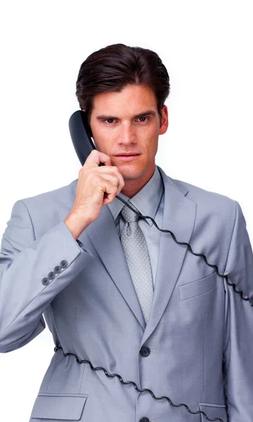Upset businessman tangle up in phone wires — Stock Photo, Image