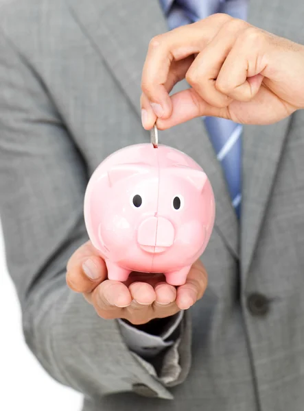Close-up of a businessman saving money in a piggy-bank — Stock Photo, Image