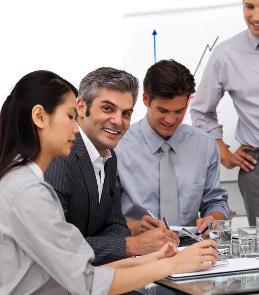 Sonriente maduro gerente en una reunión con su equipo — Foto de Stock