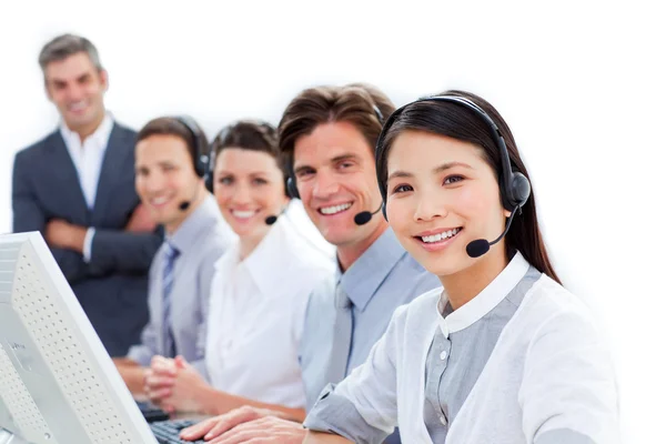 Sorrindo equipe de negócios falando sobre fone de ouvido — Fotografia de Stock