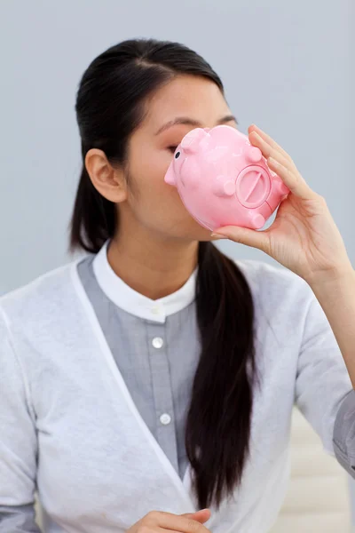 Businesswoman kissing a piggybank — Stock Photo, Image