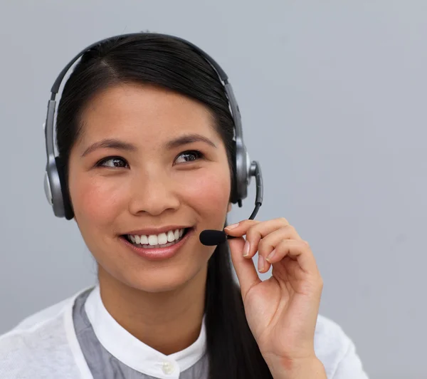 Servizio clienti etnico sorridente che parla su un auricolare — Foto Stock