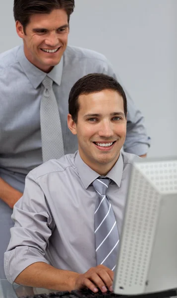 Lächelnder Manager überprüft die Arbeit seines Mitarbeiters — Stockfoto