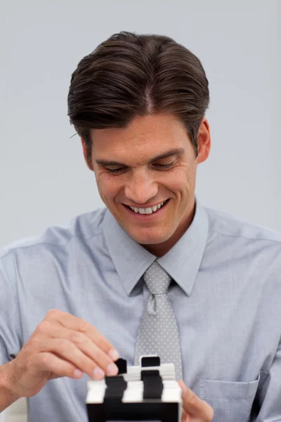 Cheerful businessman consulting a business card holder — Stock Photo, Image