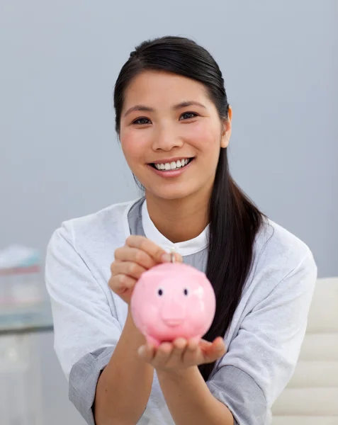 Чарівна азіатська бізнес-леді заощаджує гроші в скарбничку — стокове фото
