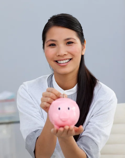 stock image Charming asian businesswoman saving money in a piggybank