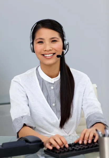 Etnische klantenservice met hoofdtelefoon op — Stockfoto