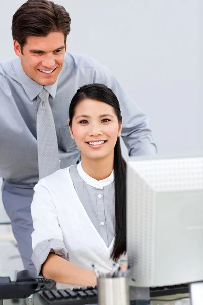 Mulher de negócios asiática e seu colega trabalhando em um computador — Fotografia de Stock