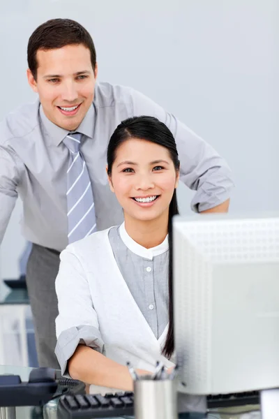 Красивая деловая женщина и ее коллега, работающие за компьютером — стоковое фото