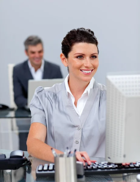 Bir bilgisayarda çalışan iş kadın gülümsüyor — Stok fotoğraf