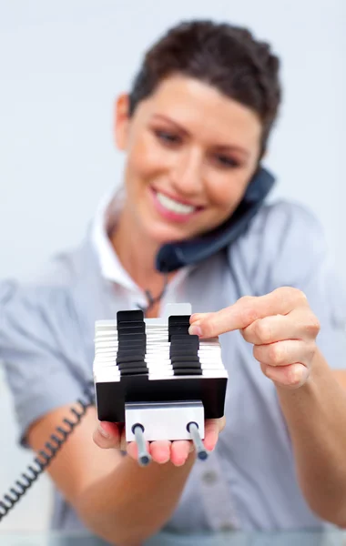 Mujer de negocios sonriente en el teléfono en busca del índice — Foto de Stock